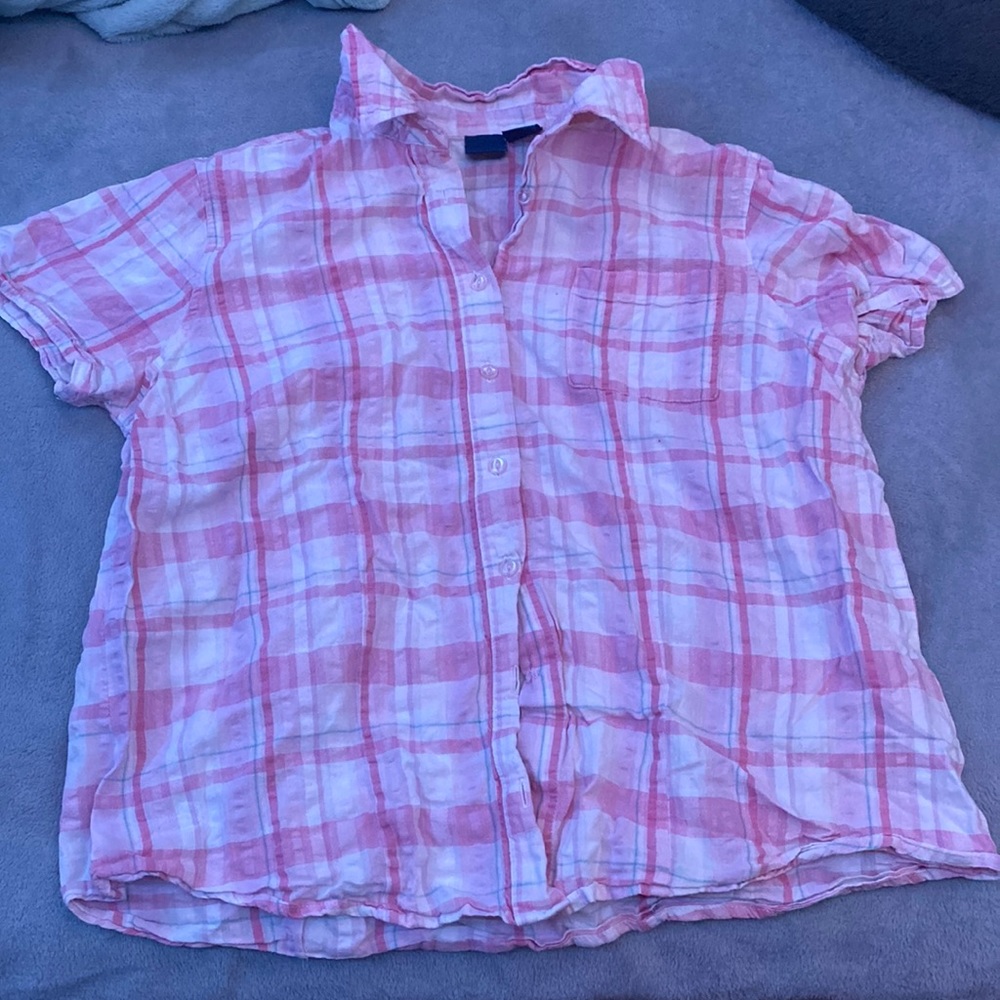 Pink and white collared and buttoned up shirt.